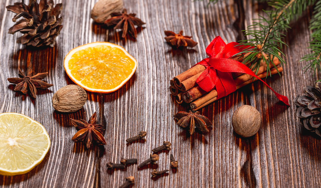 Корица на столе с орехами, бадьяном, сушеными апельсинами и гвоздикой