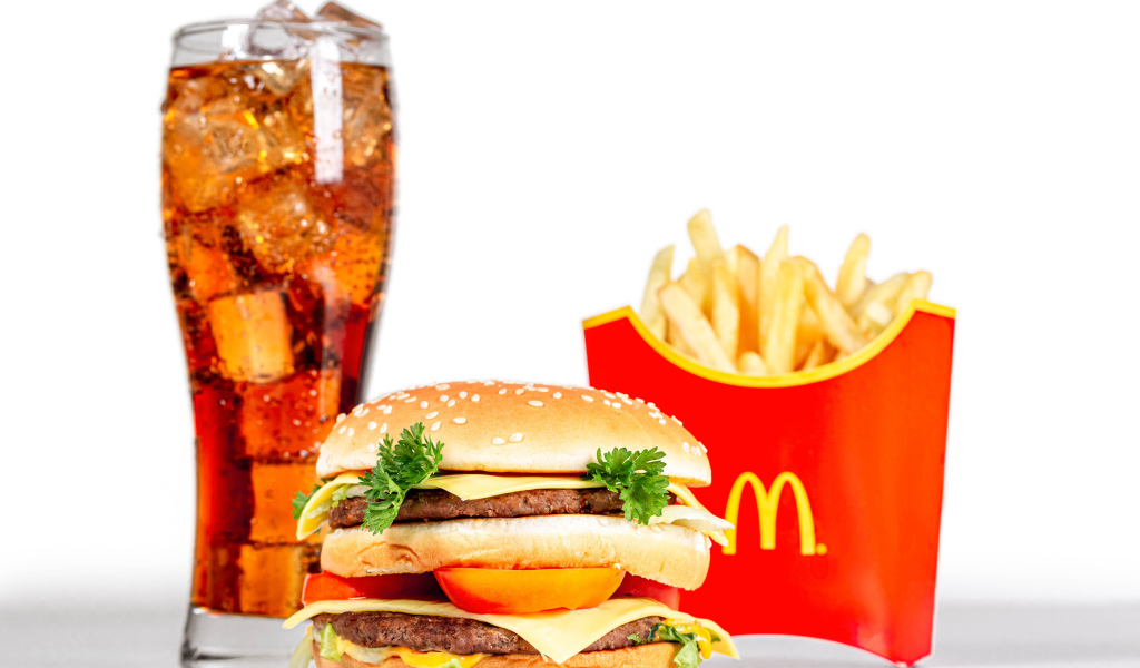 Coca cola with ice on a white plate with hamburger and fries