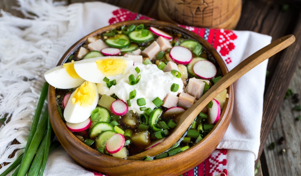 Холодная окрошка в деревянной миске на столе 