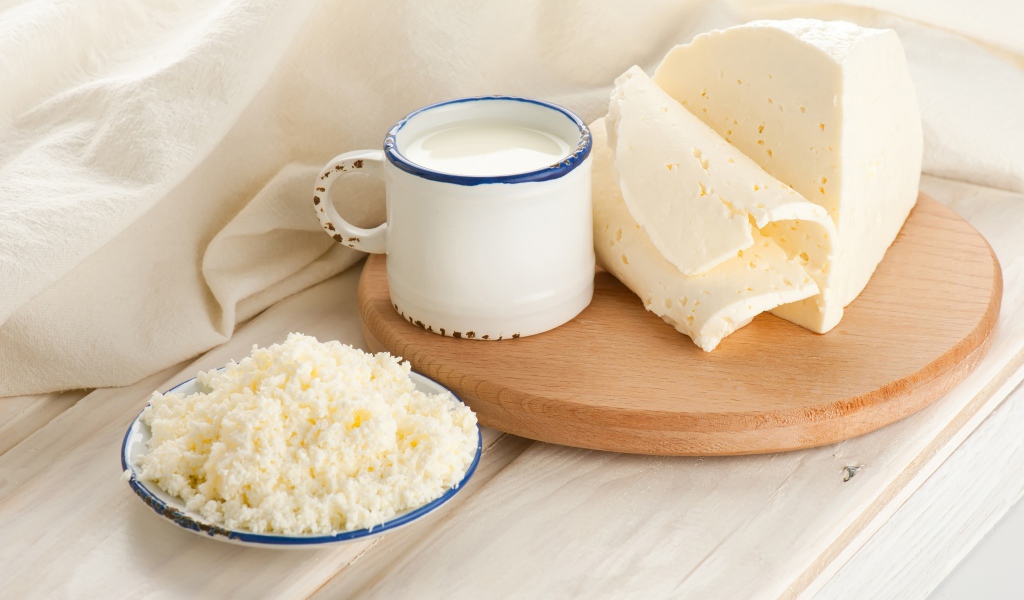 Творог, сыр и кружка молока на столе 