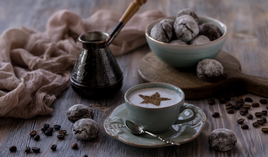 Чашка кофе на столе с пряниками и зернами