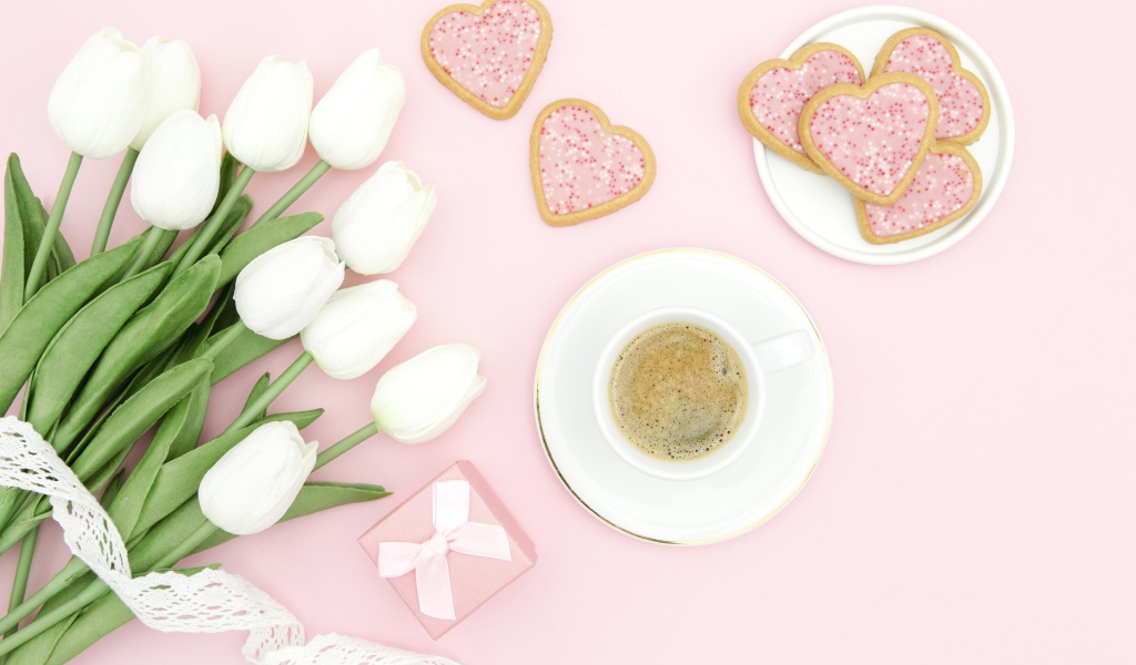 Чашка кофе с печеньем на столе с букетом белых тюльпанов