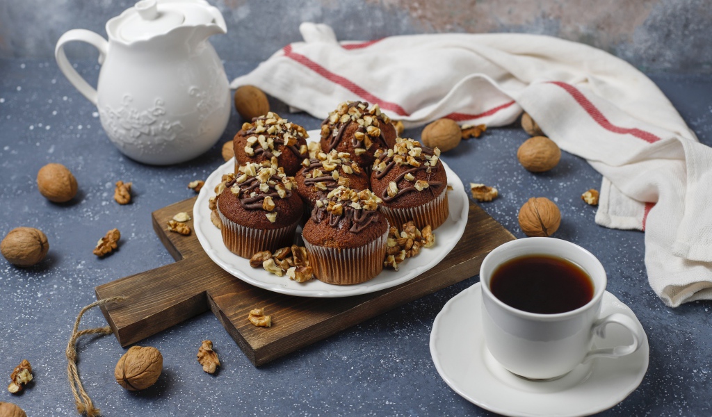 Вкусные шоколадные кексы с орехами на столе с кофе