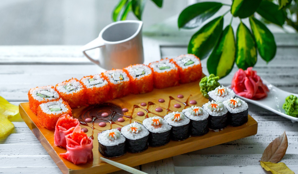 Вкусные суши и роллы на столе с имбирем