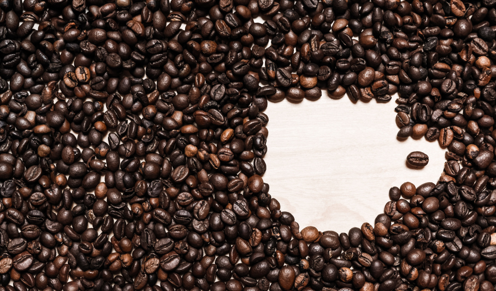 Рисунок чашки из кофейных зерен на столе