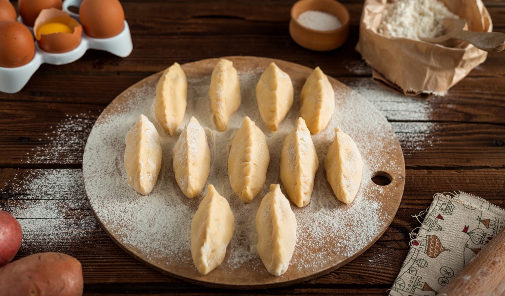 Вареники с картошкой на доске с мукой