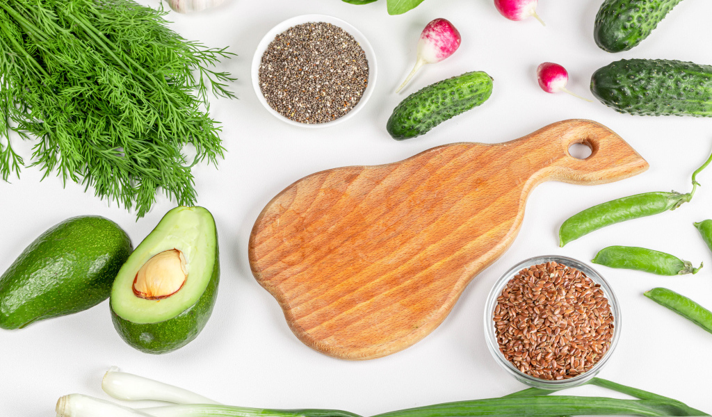 Свежие огурцы, авокадо, редис и укропом на столе с зернами