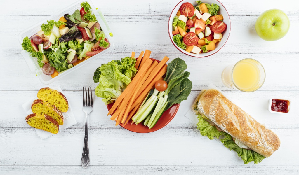 Салат из свежих овощей на столе с бутербродом 