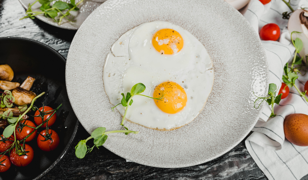 Яичница глазунья с овощами на столе 