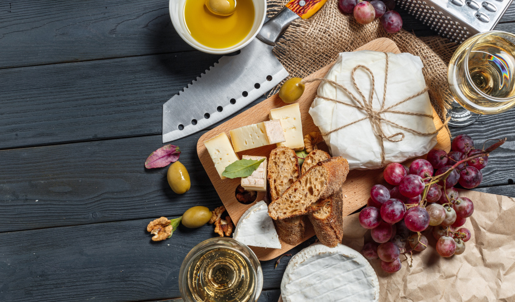 Виноград на столе с сыром, хлебом и оливками