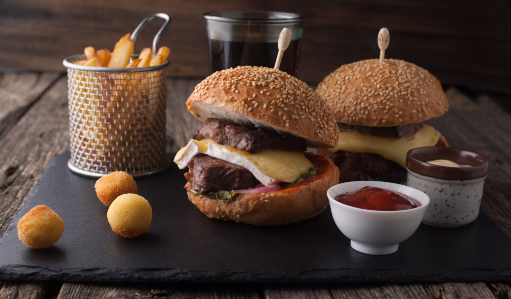 Гамбургеры с мясо на столе с картофелем фри и соусом