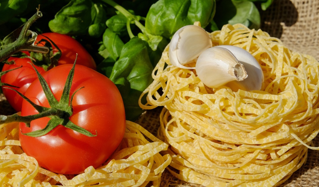 Домашняя лапша на столе с помидорами и базиликом