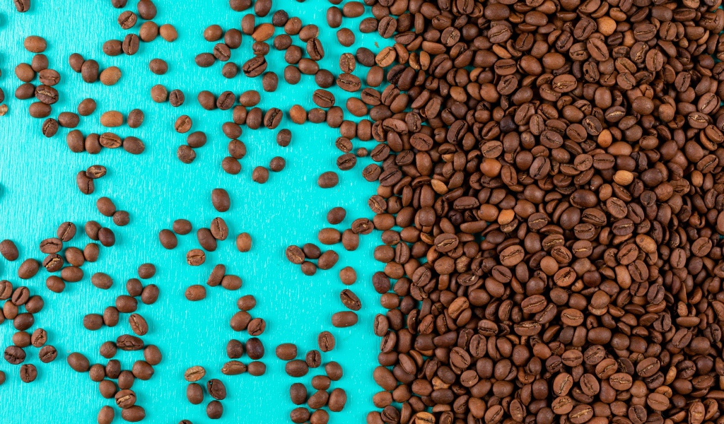 Много обжаренных кофейных зерен на голубом фоне