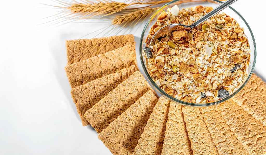 Мюсли в тарелке на столе с хлебцами 