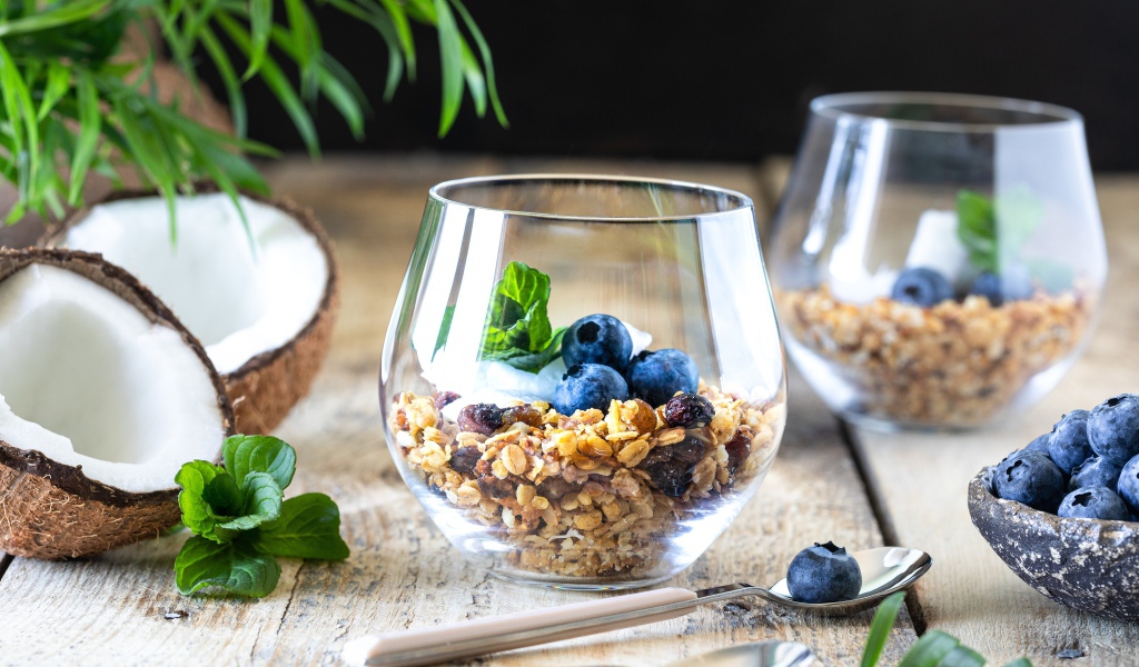 Мюсли с ягодами черники на столе с кокосом