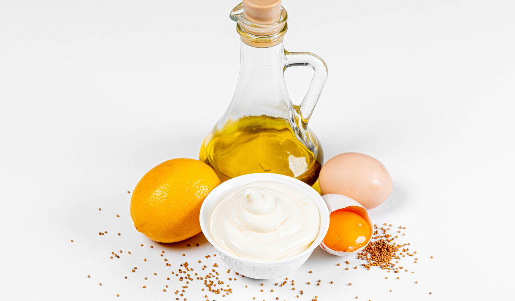 Оливковое масло, яйца и лимон на белом фоне с майонезом