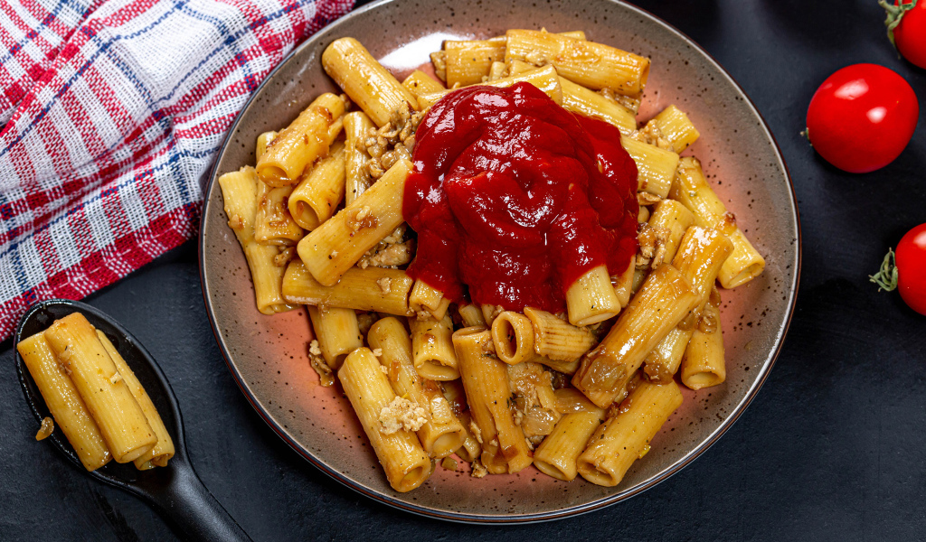 Pasta with meat and ketchup on the table