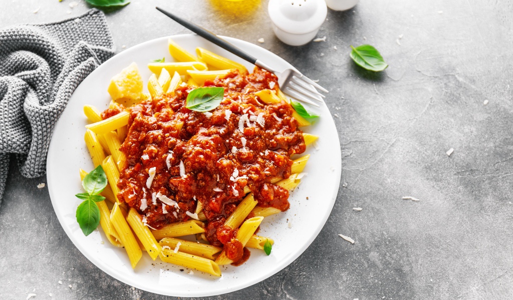 Макароны с соусом на белой тарелке