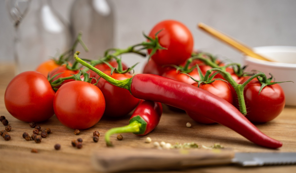 Красный острый перец с помидорами на столе