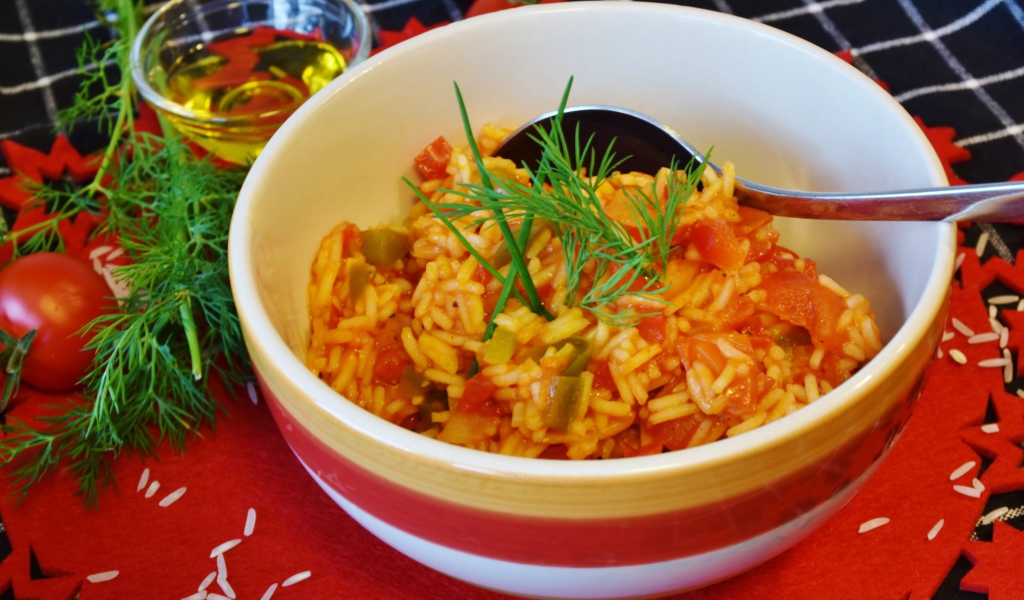 Рис с овощами в тарелке на столе