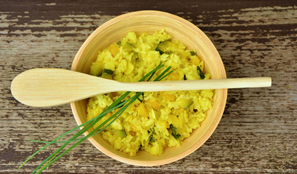 Блюдо ризотто в деревянной миске с ложкой