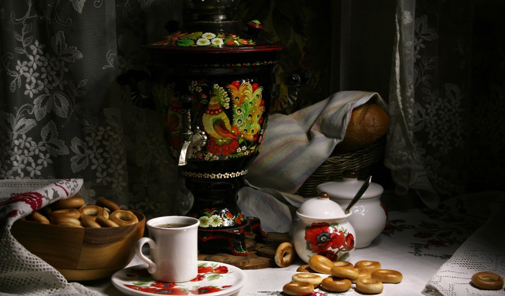 Самовар стоит на столе с чаем и баранками