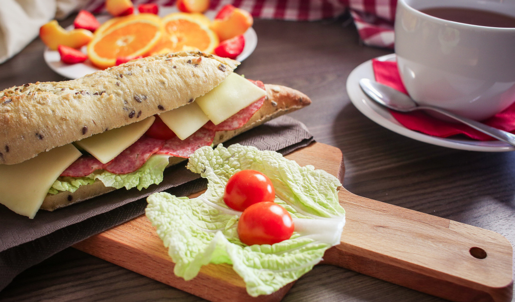 Бутерброды на столе с фруктами и чашкой чая