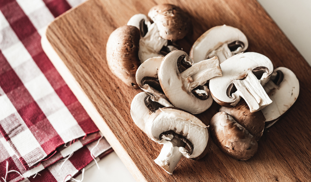 Нарезанные шампиньоны на разделочной доске