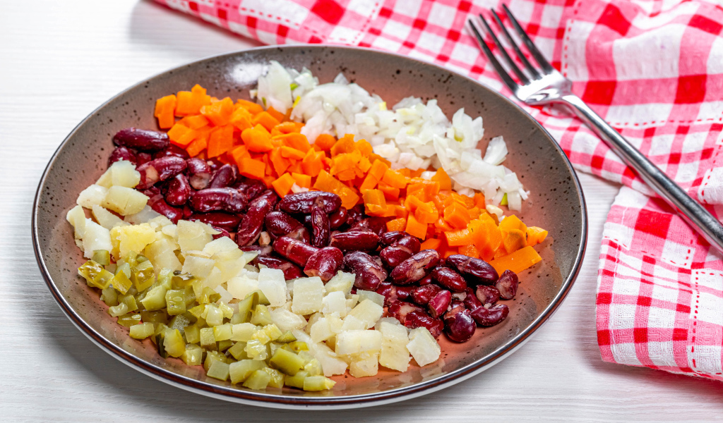 Овощи и фасоль нарезанные на тарелке 