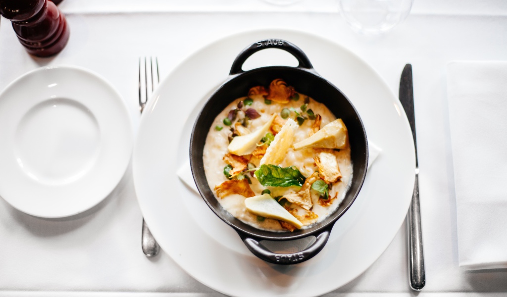 Суп в миске стоит на белой тарелке 