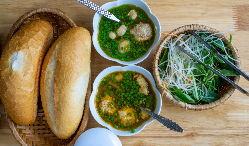 Суп с фрикадельками на столе с хлебом и салатом 