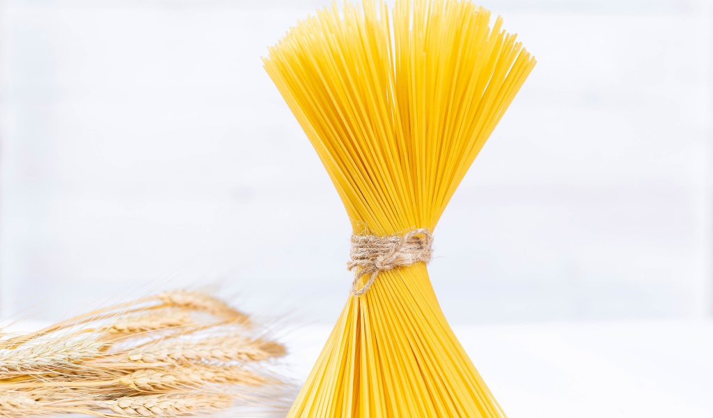 Спагетти перевязаны ниткой на белом фоне