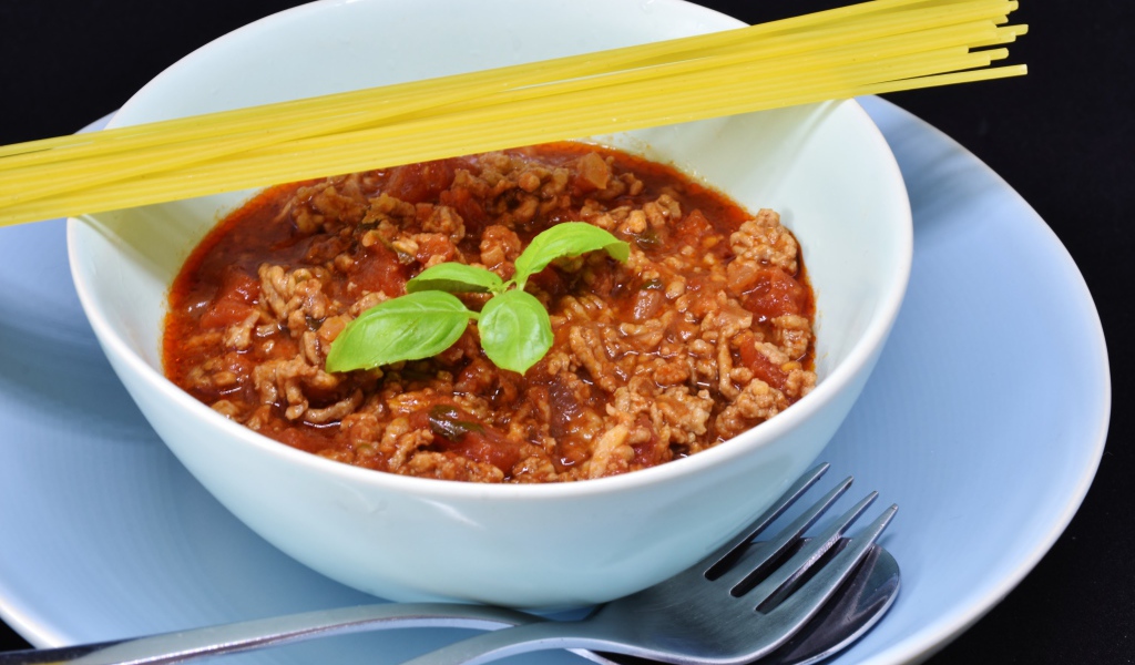 Спагетти с острым соусом с мясом на столе 