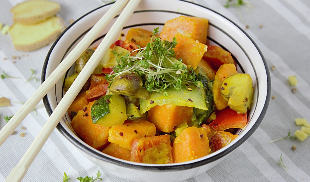 Острое блюдо из овощей в миске с палочками