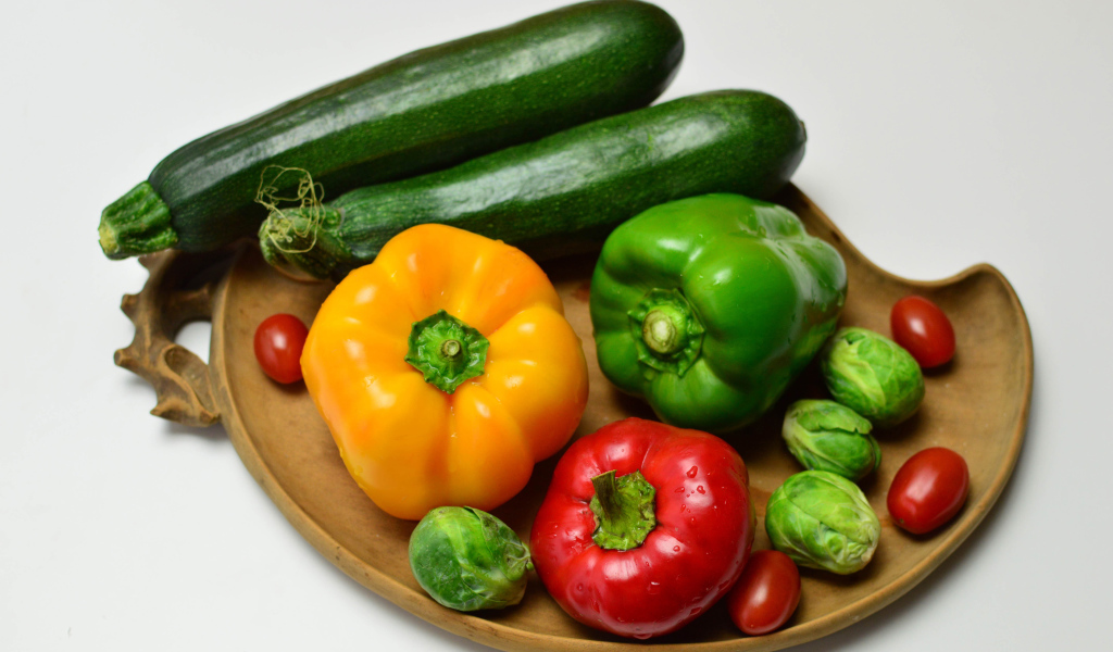 Сладкий перец, кабачки, помидоры и брюссельская капуста на сером фоне