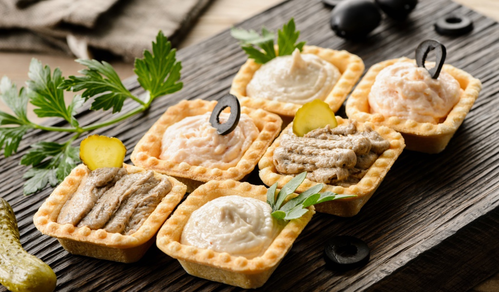 Тарталетки с паштетом на столе с оливками 