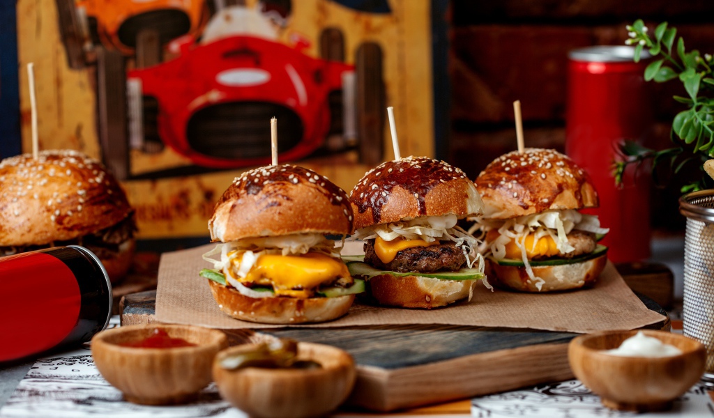 Вкусные гамбургеры на столе с соусом и кока колой 