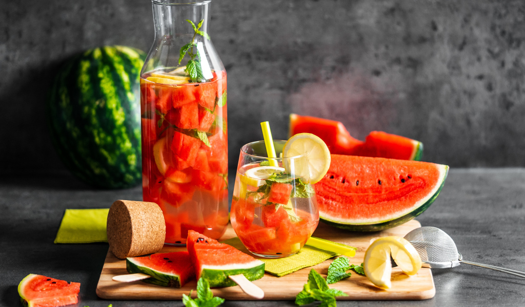 Вкусный напиток на столе с кусочками арбуза 