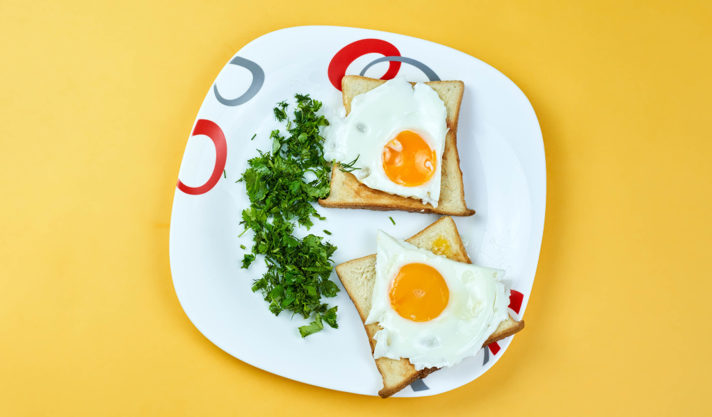 Тосты с яичницей на тарелке с зеленью петрушки 