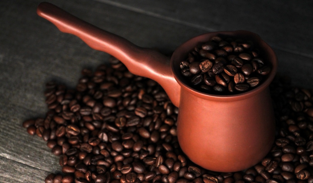 Турка с кофейными зернами на столе 