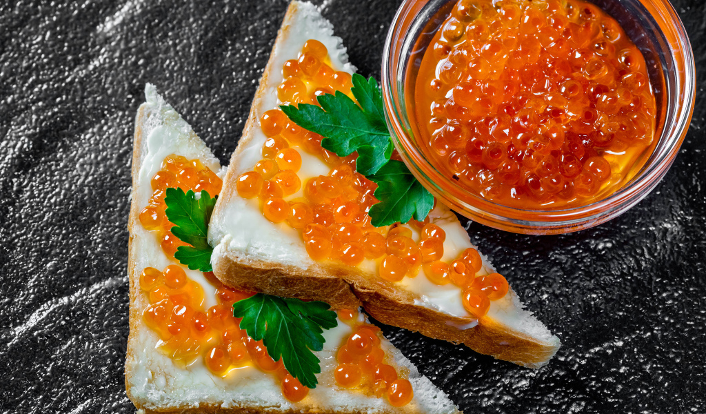 Два бутерброда с красной икрой на столе