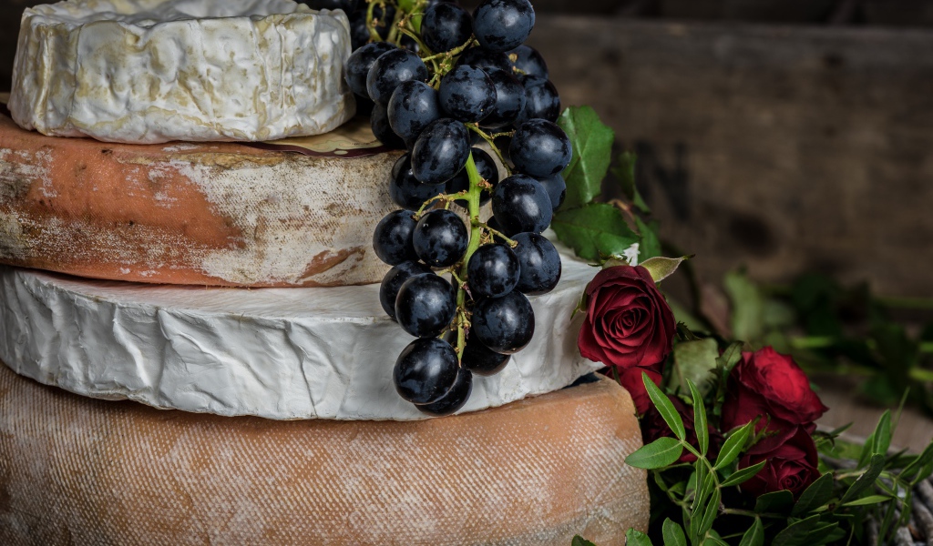 Гроздь синего винограда на столе с сыром с плесенью 