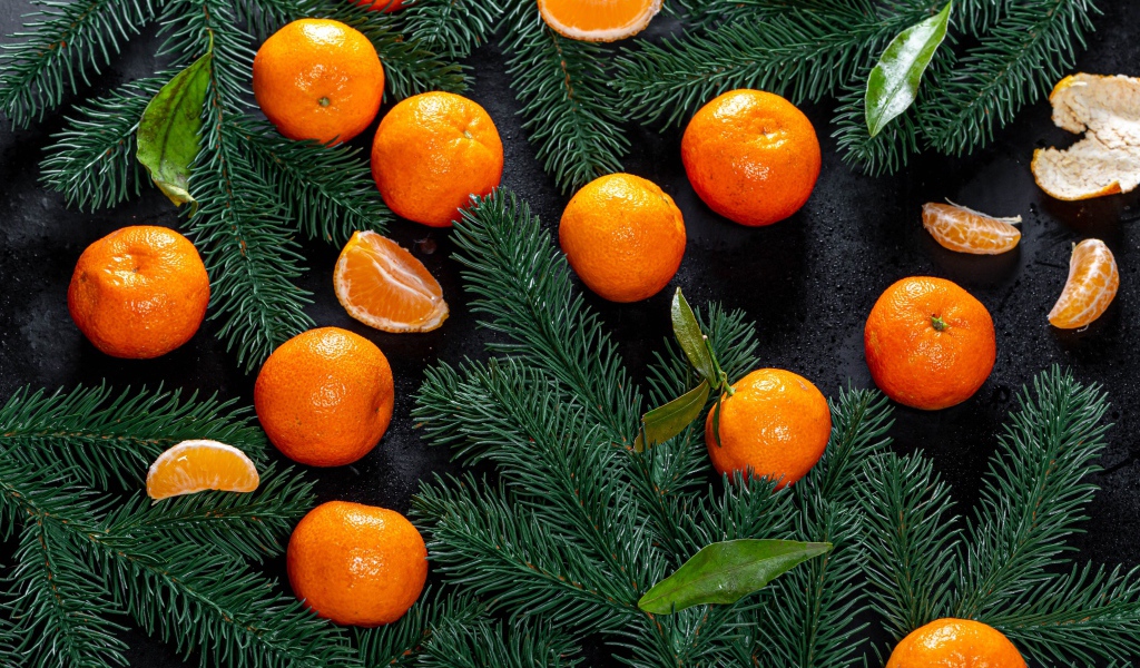 Много мандаринов на столе с еловыми ветками