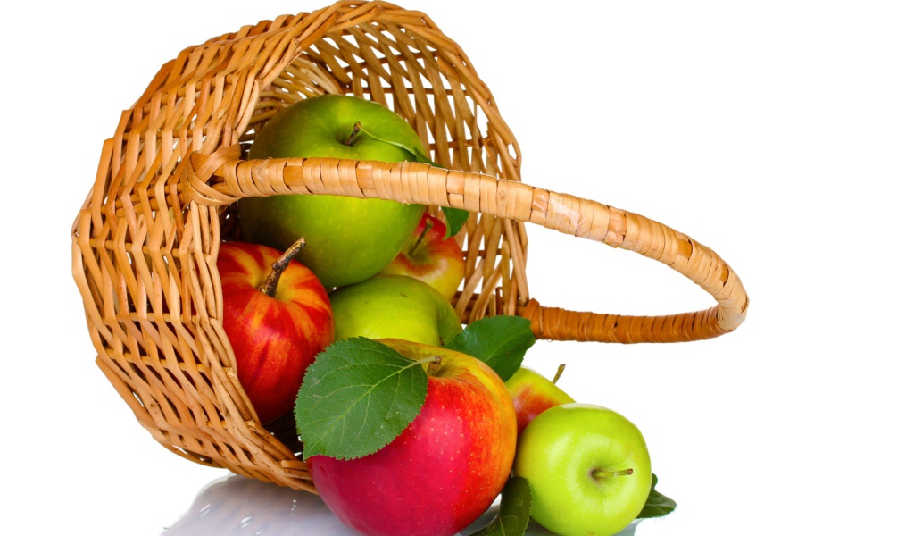 Красивые разноцветные яблоки в корзине на белом фоне
