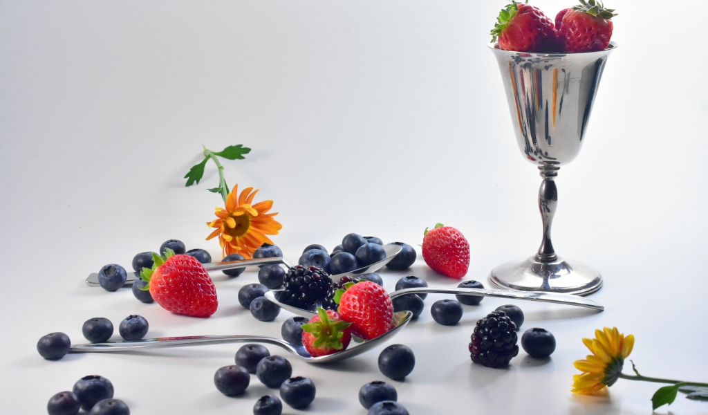 Ежевика, черника и клубника на столе с ложками