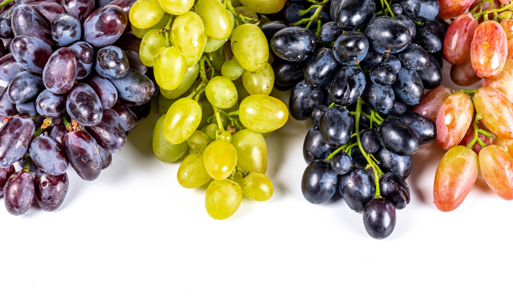 Грозди разноцветного винограда на белом фоне
