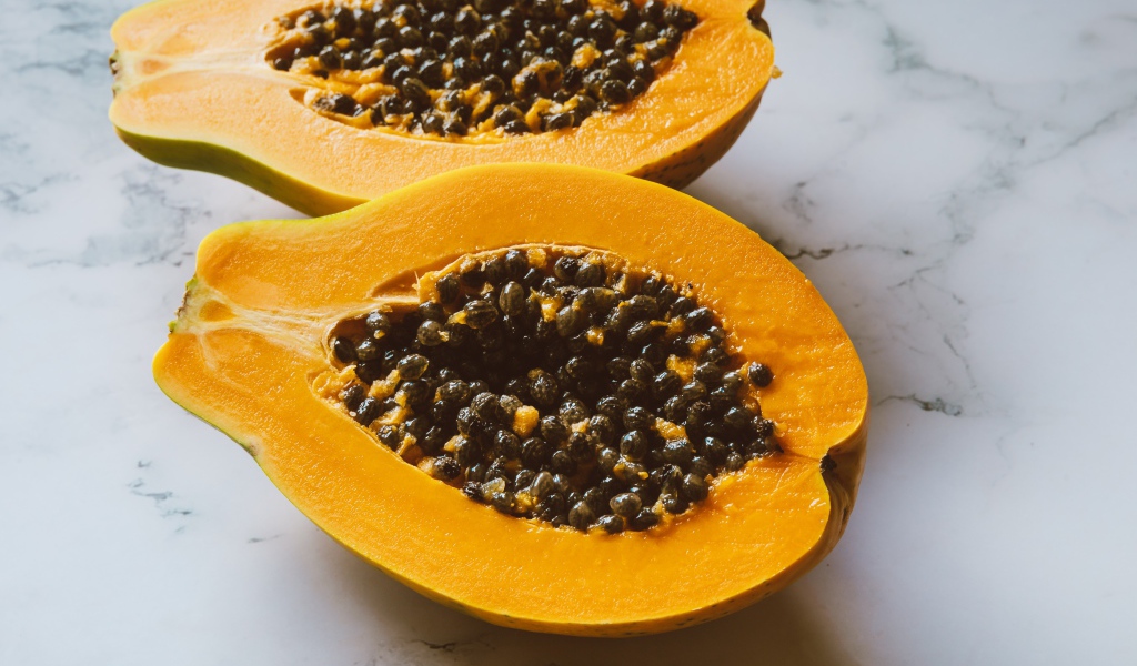 Разрезанный плод папайи на столе 