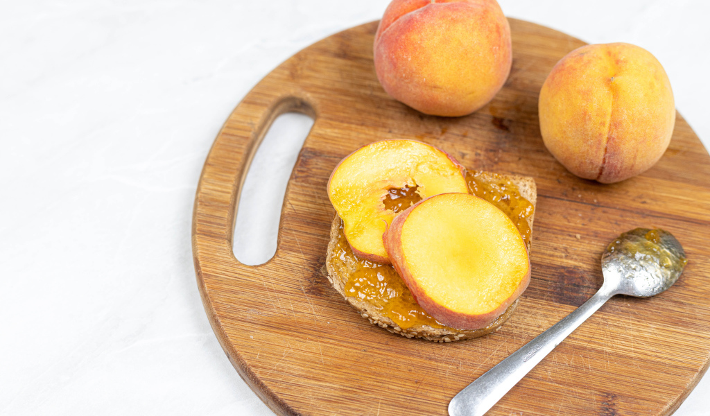 Свежие персики на столе с хлебом 