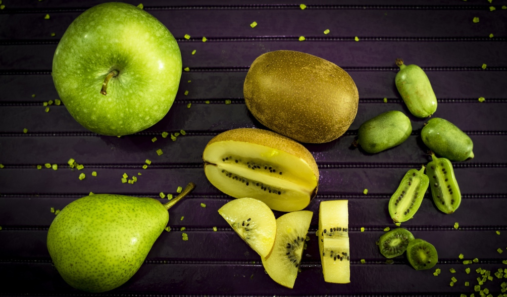 Зеленое яблоко на столе с грушей, киви и фейхоа 