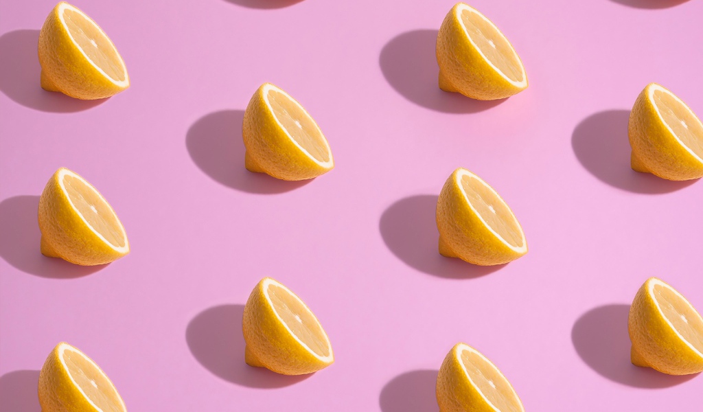 Половинки лимона на розовом фоне